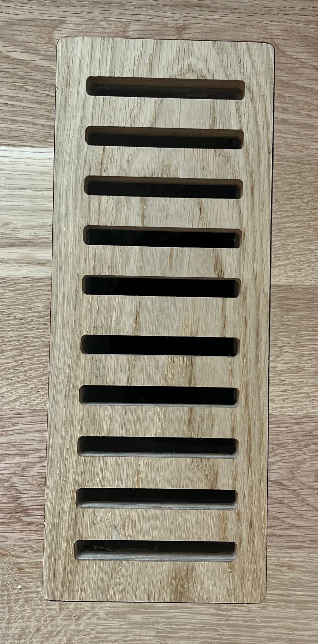 Custom flush mount white oak floor vent installed and stained to match hardwood floor Clayton NC