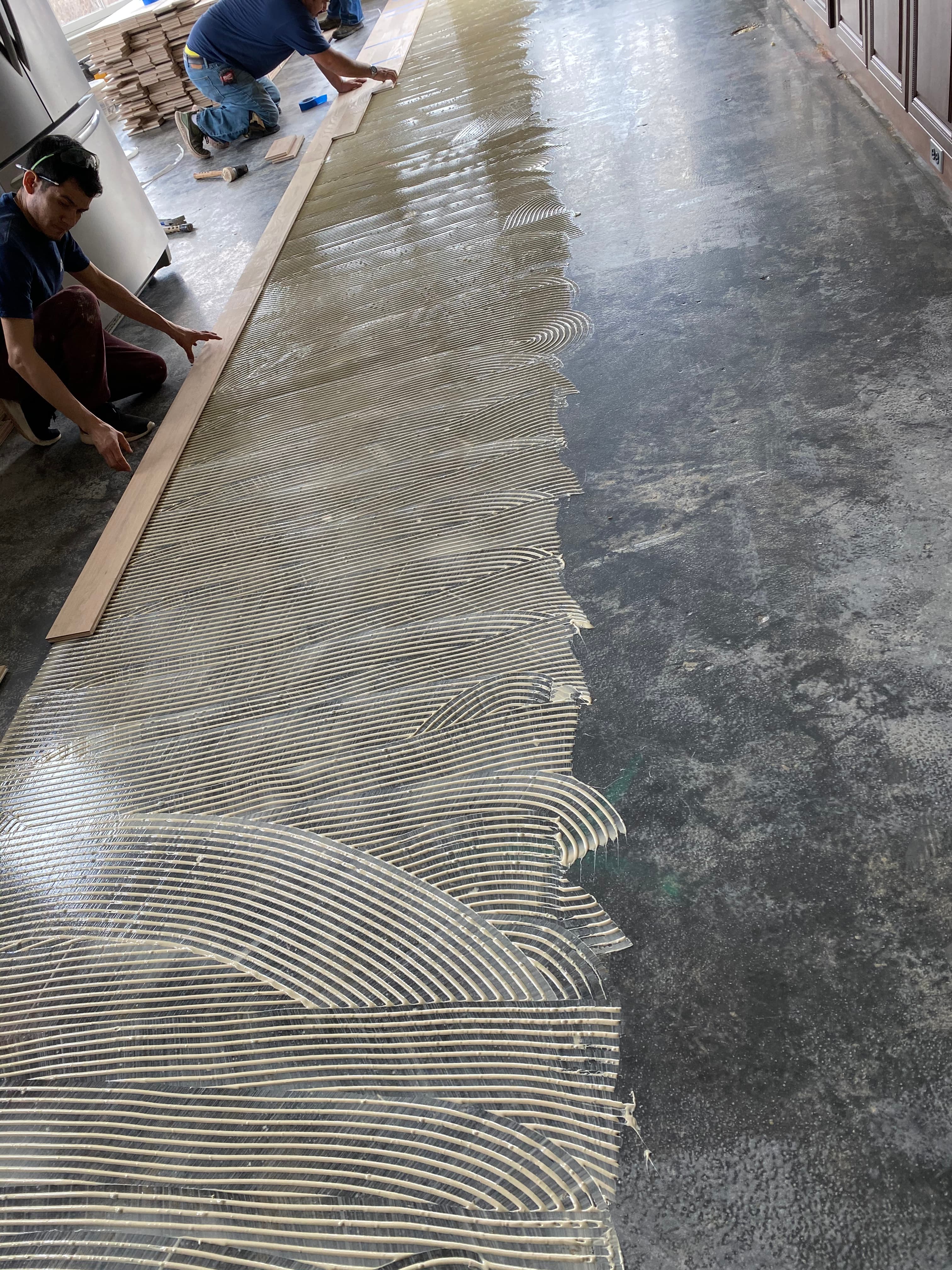 Hardwood floor glue-down installation adhesive applied over concrete subfloor Clayton NC