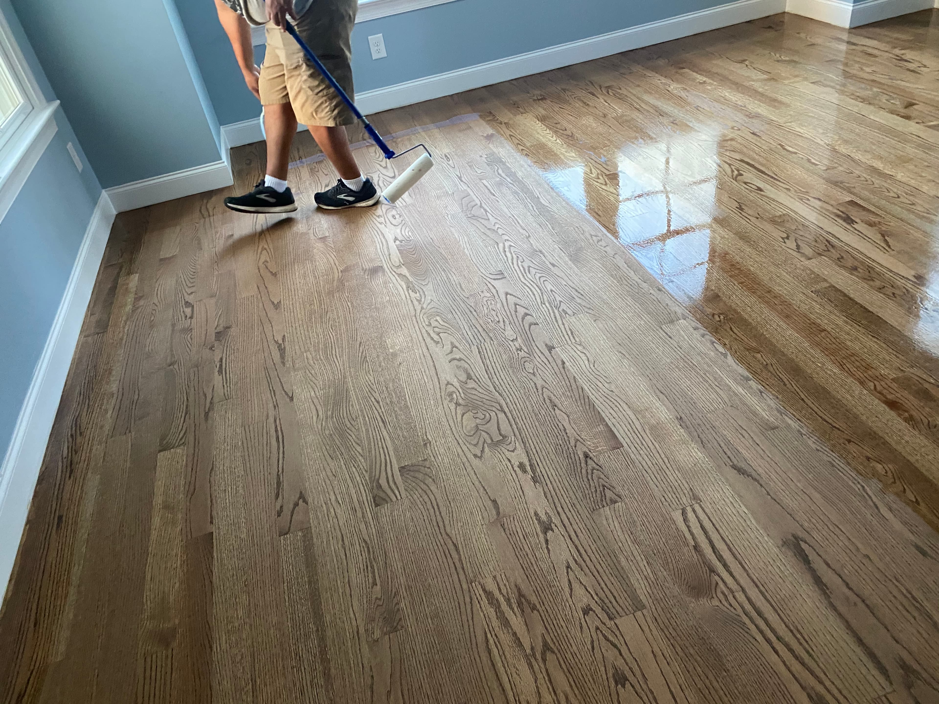 Hardwood floor recoating in progress with roller applicator on red oak floors by 12th And Oak Floor Co.