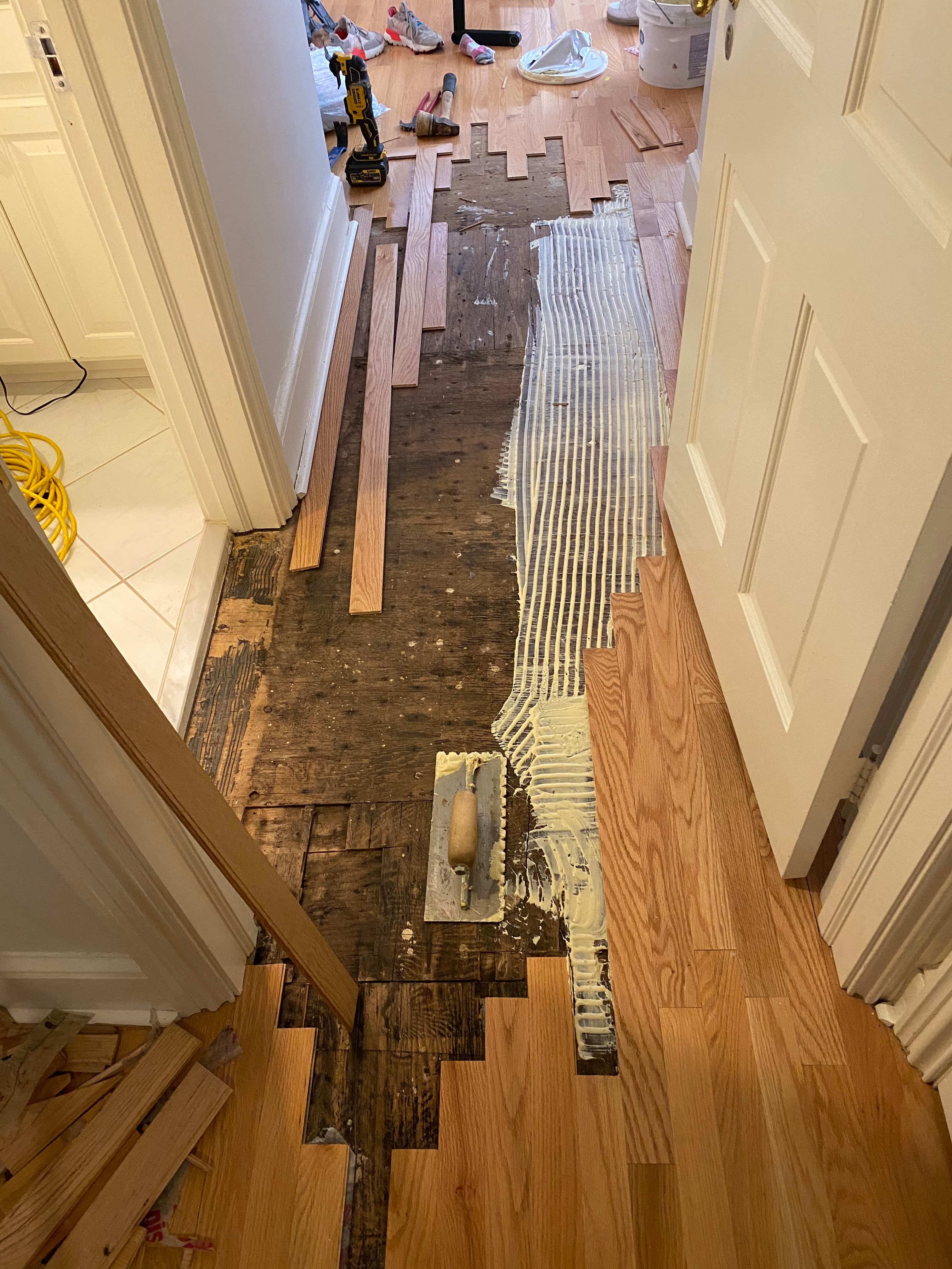 Hardwood floor water damage repair in progress with board replacement and adhesive by 12th And Oak Floor Co. Clayton NC