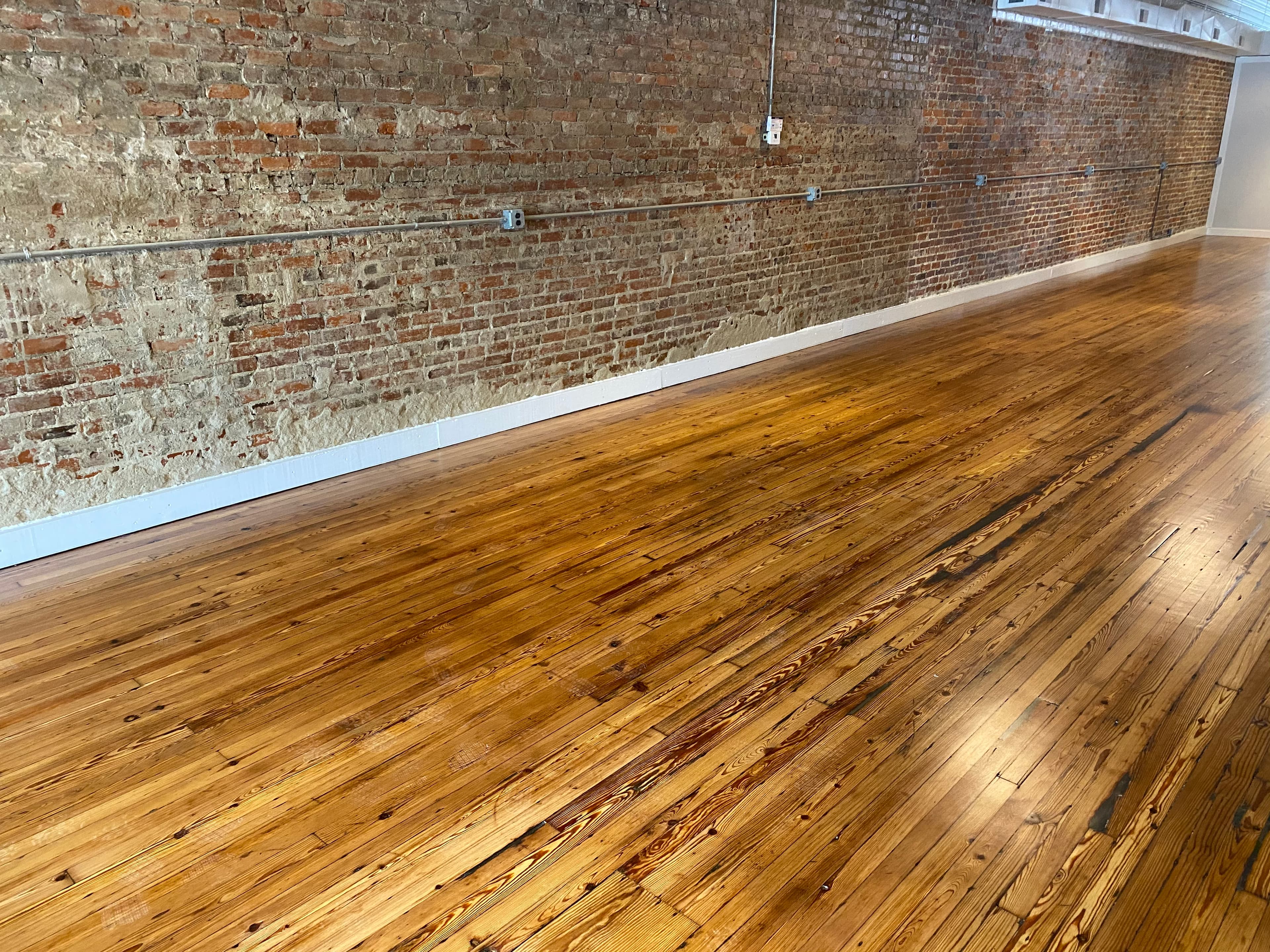 Original heart pine floors refinished at Hometown Realty in Historic Downtown Selma NC by 12th And Oak Floor Co.