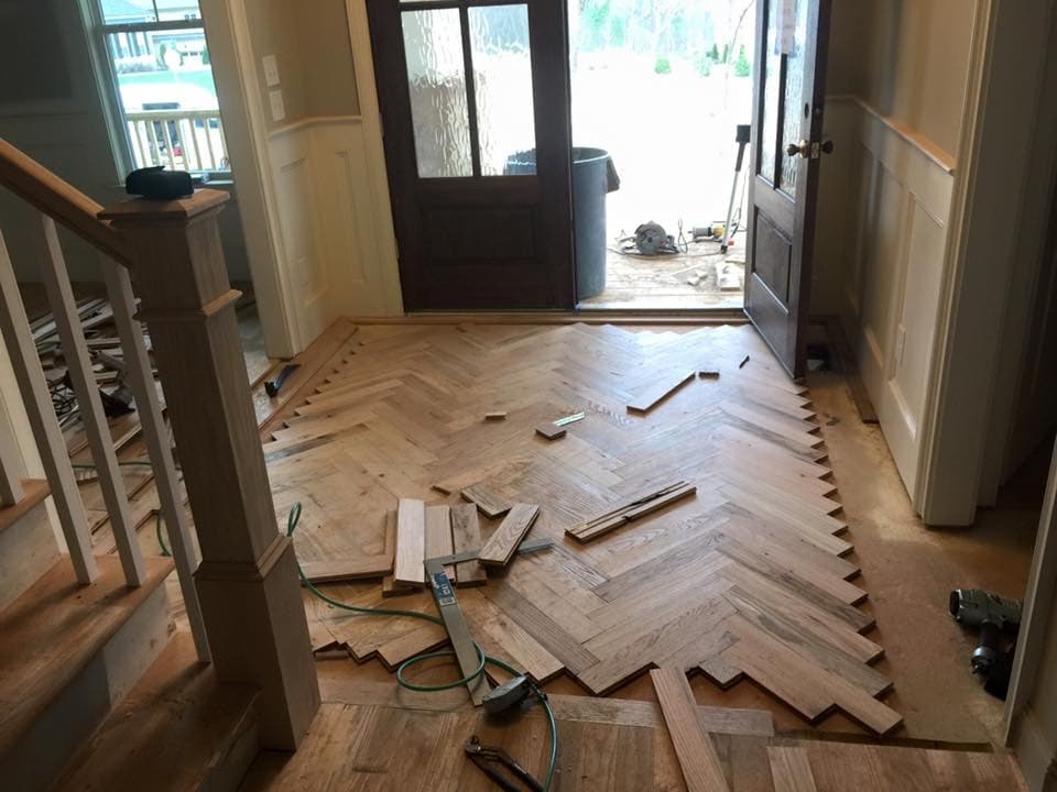 Herringbone hardwood floor installation in progress in foyer in Garner NC