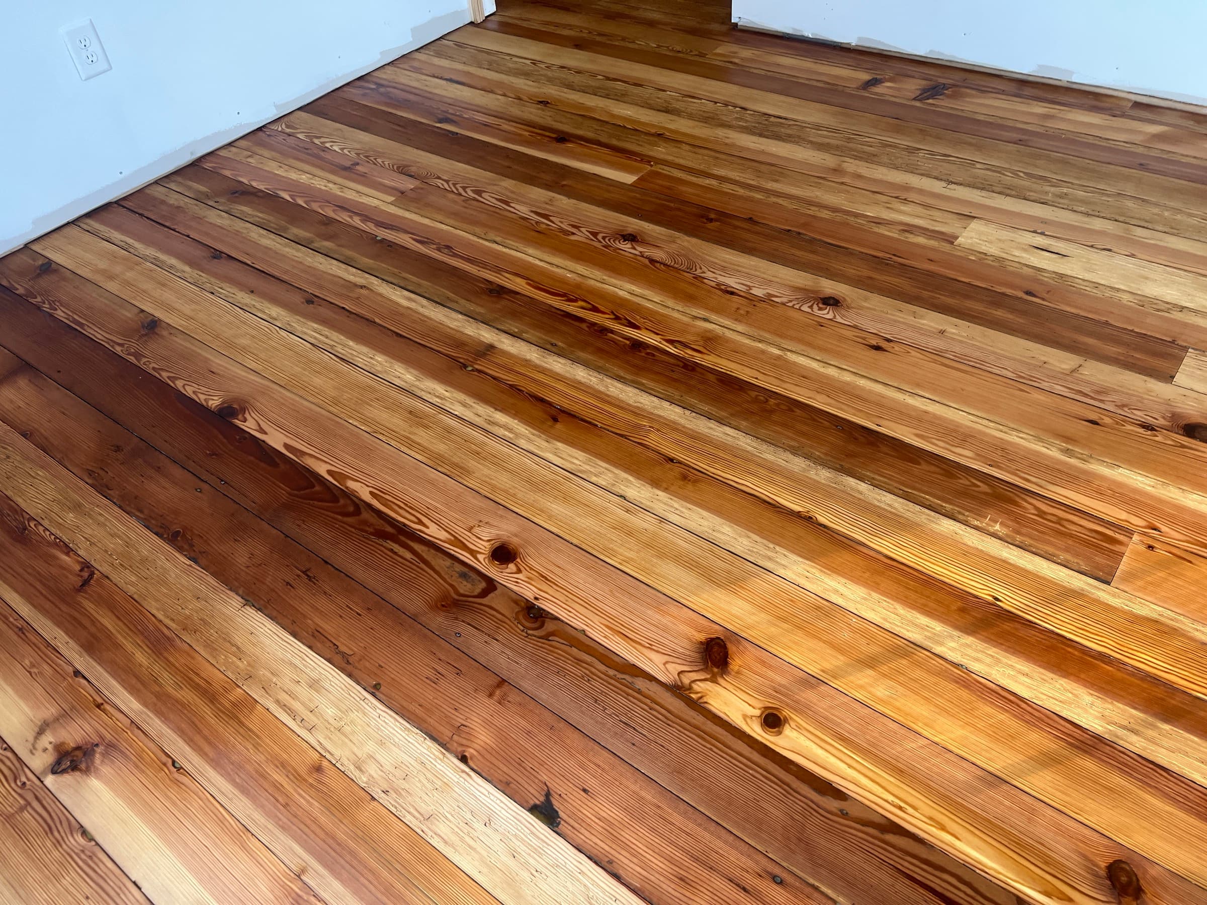 Finished historic heart pine floors in Morrisville NC, honey amber tones with knots and old-growth character after refinishing