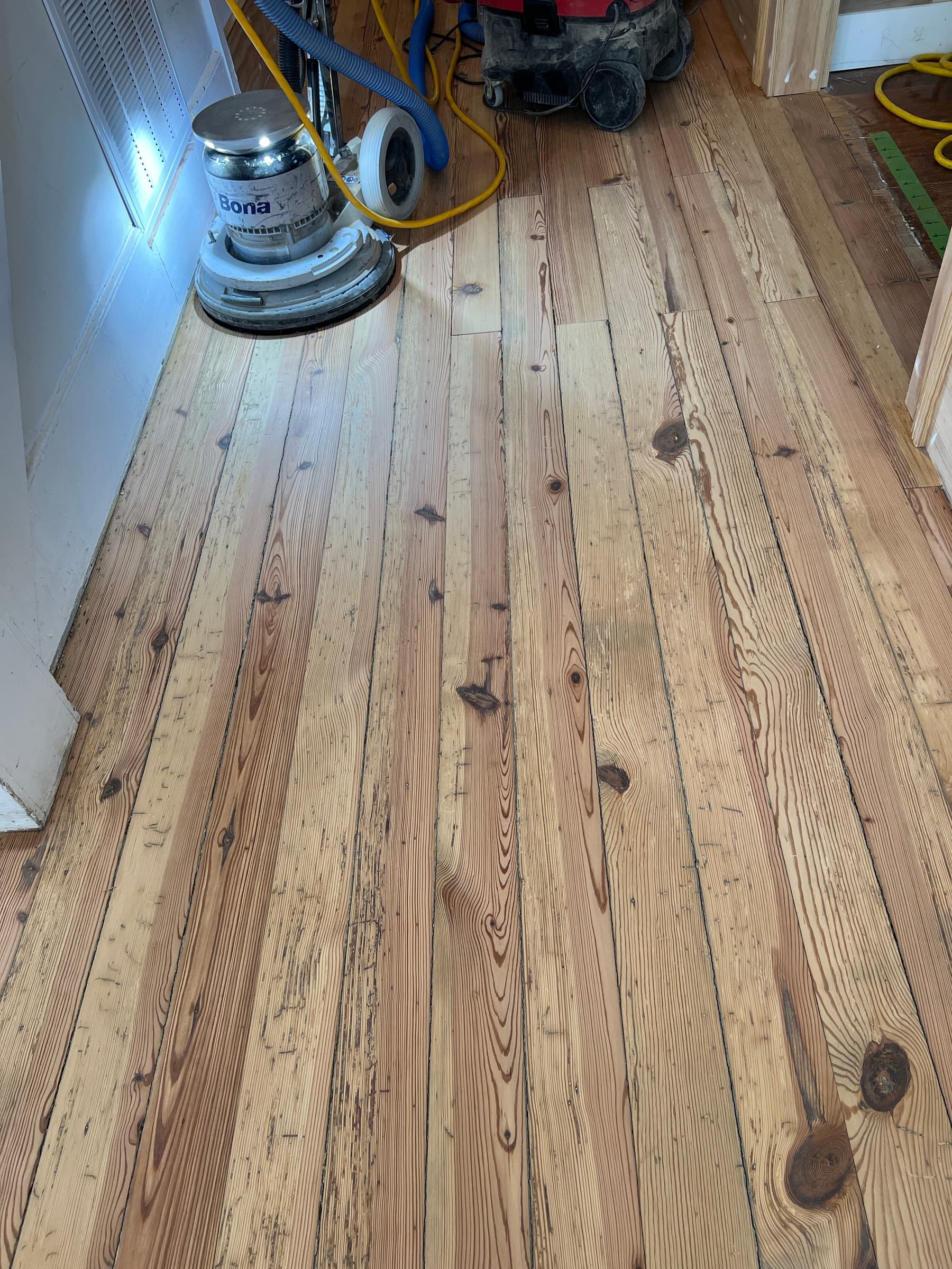 Bona edge sander working perimeter detail on sanded heart pine floors in Morrisville NC historic property