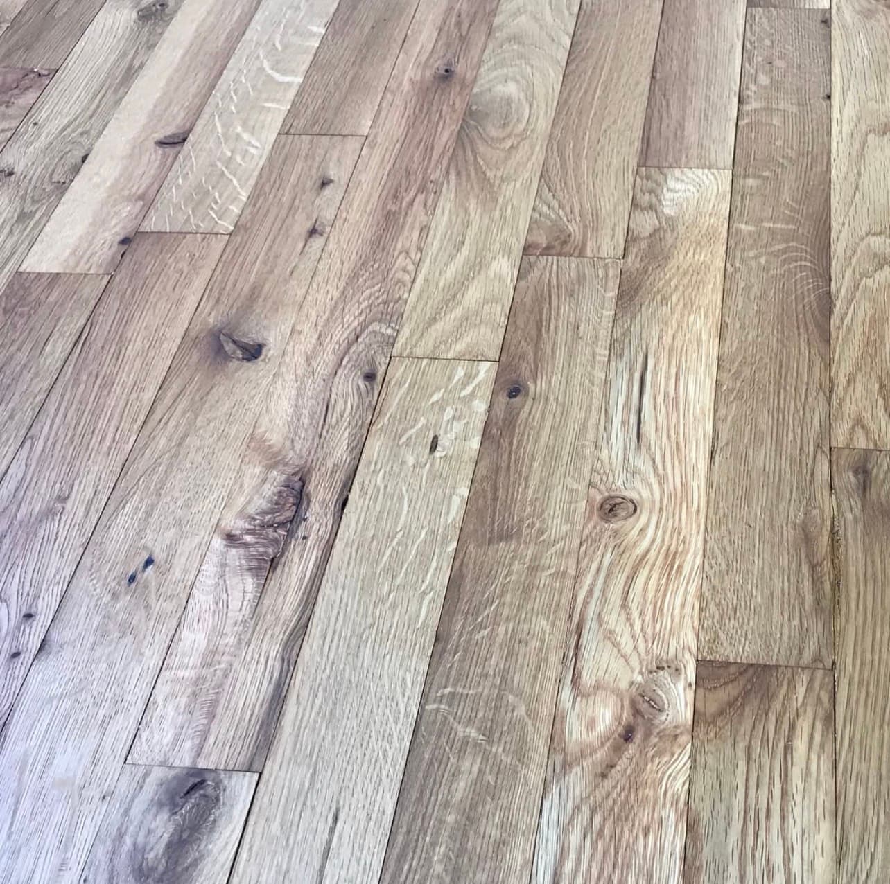 White oak hardwood floor showing natural grain and character knots before finishing Clayton NC